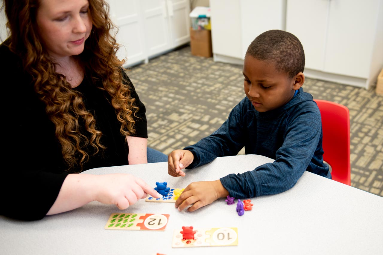 Young boy practices counting with instructor at therapeutic day school at Carolina Therapeutics Academy in Rock Hill, SC